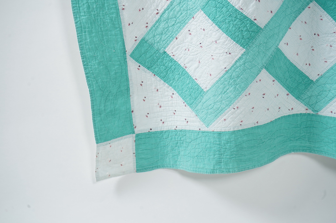 A late 19th early 20th century English, Durham, immaculately hand quilted bedcover. Designed using a plain mint green cotton and a complimentary light floral cotton stripe, in an all over lattice design, with a mint gree